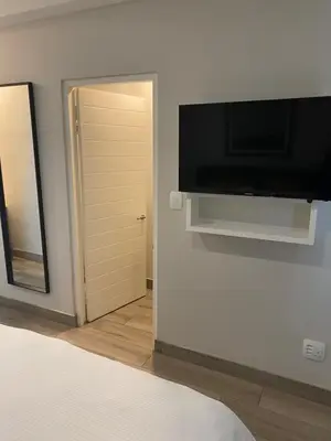 a bedroom with a flat screen tv on a wall at Luxurious 2 bedroom @ The Regency Hotel in Pretoria
