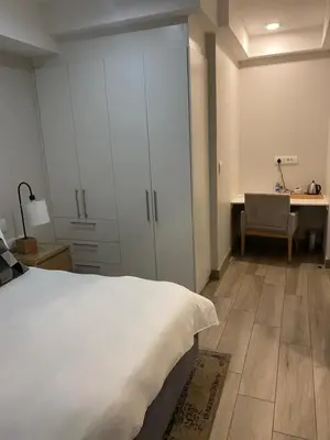 a bedroom with a white bed and a desk at Luxurious 2 bedroom @ The Regency Hotel in Pretoria