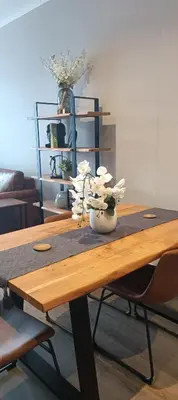 a wooden table with a vase of flowers on it at Menlyn Maine Trilogy Apartment 1215 in Pretoria