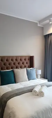 a bedroom with a large bed with two towels on it at Menlyn Maine Trilogy Apartment 1215 in Pretoria