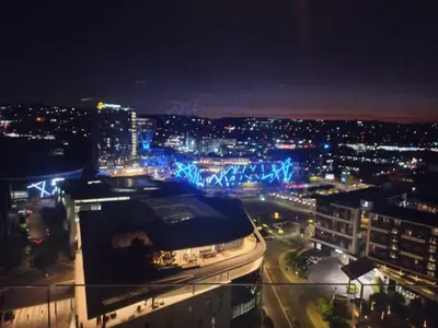a view of a city at night with a building at Menlyn Maine Trilogy Apartment 1215 in Pretoria