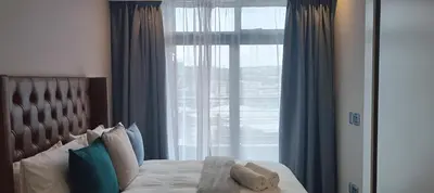 a bedroom with a bed with a large window at Menlyn Maine Trilogy Apartment 1215 in Pretoria