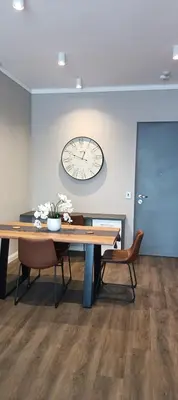 a room with a table and a clock on the wall at Menlyn Maine Trilogy Apartment 1215 in Pretoria