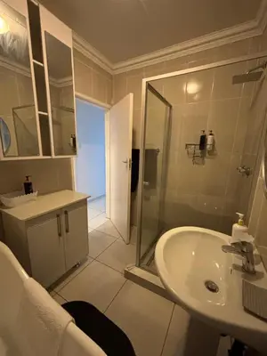 a white bathroom with a shower and a sink at Blissful stay in Polokwane