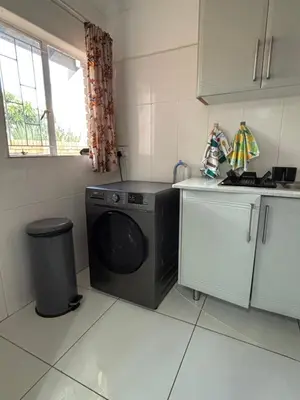 a kitchen with a washing machine and a sink at Blissful stay in Polokwane