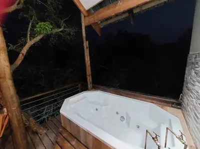 a bath tub sitting on top of a wooden deck at Tree Symphony in Marloth Park