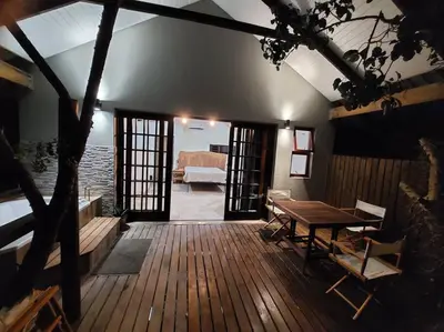 a room with a wooden deck with a table at Tree Symphony in Marloth Park
