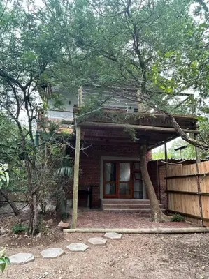 a brick house with a front porch and a tree at Tree Symphony in Marloth Park