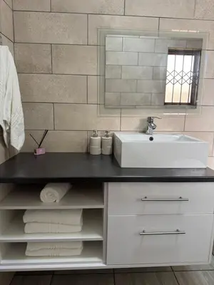 a bathroom with a sink and a counter with towels at Midrand Chic Oasis in Midrand
