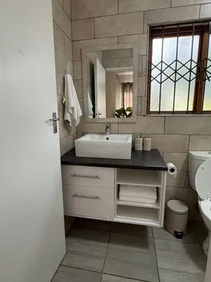 a bathroom with a sink and a mirror at Midrand Chic Oasis in Midrand