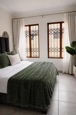 a bedroom with a large bed and two windows at Midrand Chic Oasis in Midrand