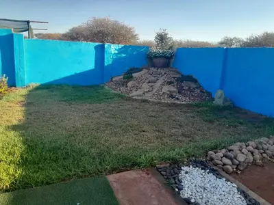 a blue fence with a plant on top of a yard at Letz Guest Lodge in Bochum