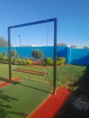 a swing in a playground with a blue fence at Letz Guest Lodge in Bochum