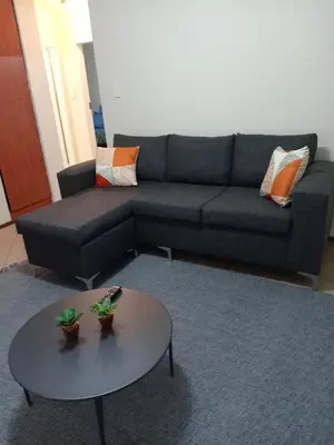 a living room with a couch and a table at Alternate Cosy Home in Pretoria