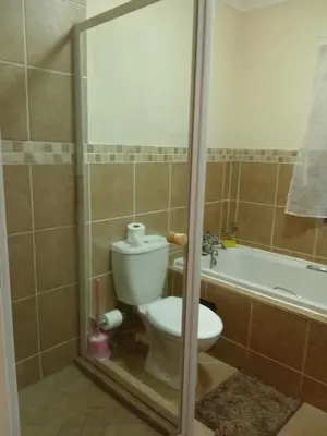 a bathroom with a toilet and a bath tub at Alternate Cosy Home in Pretoria