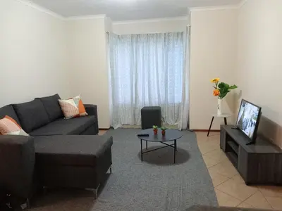 a living room with a couch and a table at Alternate Cosy Home in Pretoria