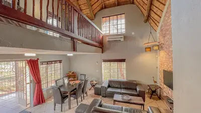 a large living room with a table and chairs at Walking Tall Private Bush Retreat in Marloth Park