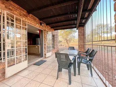 a patio with a table and chairs on a porch at Walking Tall Private Bush Retreat in Marloth Park