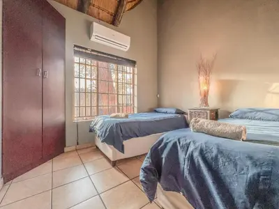 a bedroom with two beds and a window at Walking Tall Private Bush Retreat in Marloth Park