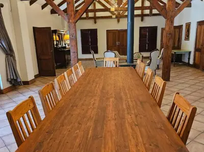 a large wooden table and chairs in a room at Arum Lily Eloff in Delmas