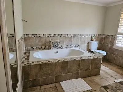 a large bathroom with a tub and a toilet at Arum Lily Eloff in Delmas