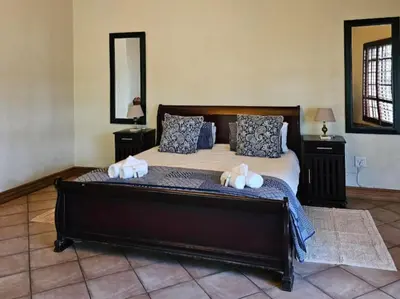 a bedroom with a large bed with towels on it at Arum Lily Eloff in Delmas
