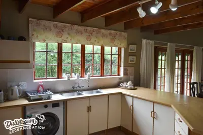 a kitchen with a sink and two windows at Forest Vista in Dullstroom