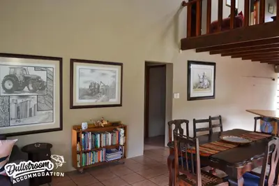 a dining room with a table and a book shelf at Forest Vista in Dullstroom