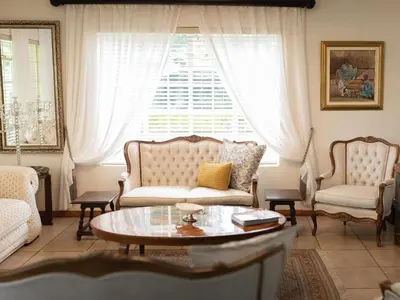 a living room with a couch and a table and a window at Rose and Ivy Cottages in Louis Trichardt