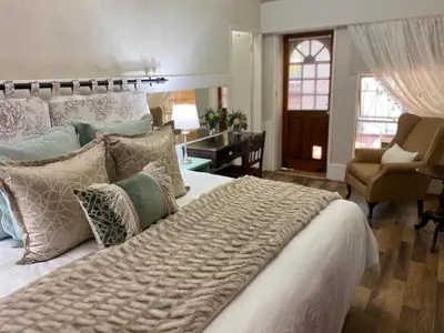 a bedroom with a large bed with pillows at Rose and Ivy Cottages in Louis Trichardt