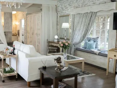 a living room with a white couch and a bed at Rose and Ivy Cottages in Louis Trichardt
