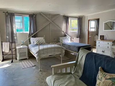 a bedroom with two beds and a couch at The Bed in the Shed in Alkmaar