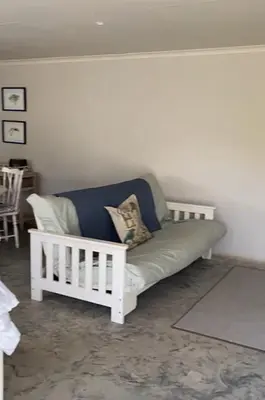 a white couch sitting in a living room at The Bed in the Shed in Alkmaar