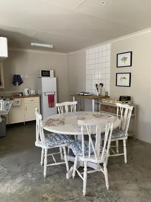 a kitchen with a table and chairs and a kitchen with a refrigerator at The Bed in the Shed in Alkmaar