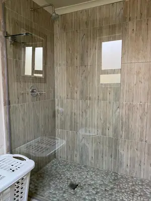 a bathroom with a shower with a stone floor at The Bed in the Shed in Alkmaar