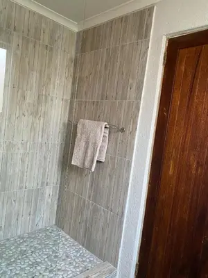 a bathroom with a shower with a towel at The Bed in the Shed in Alkmaar