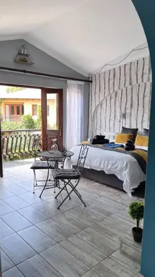 a bedroom with a bed and a table and chairs at Dullies Dolce in Dullstroom