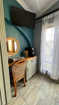 a bathroom with a table and a chair and a mirror at Dullies Dolce in Dullstroom