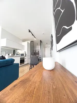 a living room with a blue couch and a wooden table at ERL Ellipse Waterfall. in Midrand