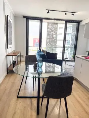 a living room with a glass table and chairs at ERL Ellipse Waterfall. in Midrand