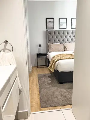 a bedroom with a bed with a gray headboard at ERL Ellipse Waterfall. in Midrand