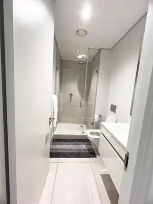 a white bathroom with a shower and a toilet at ERL Ellipse Waterfall. in Midrand