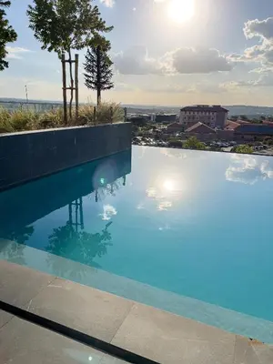 a swimming pool with a view of a city at ERL Ellipse Waterfall. in Midrand