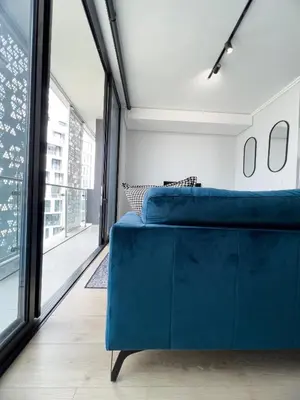 a blue couch in a room with a large window at ERL Ellipse Waterfall. in Midrand