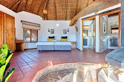 a living room with a bed and a fireplace at Thula-Thula Private Game Lodge Mabalingwe in Bela-Bela