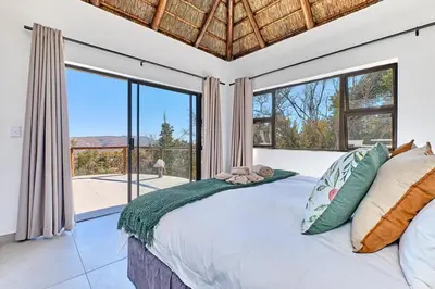a bedroom with a bed and a large window at Thula-Thula Private Game Lodge Mabalingwe in Bela-Bela