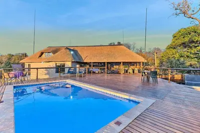a house with a swimming pool on a wooden deck at Thula-Thula Private Game Lodge Mabalingwe in Bela-Bela