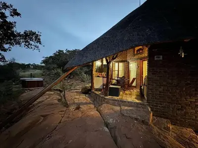 a small brick house with a thatched roof at Thula-Thula Private Game Lodge Mabalingwe in Bela-Bela