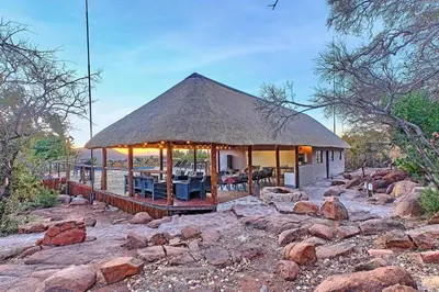 a large building with a thatched roof on top of rocks at Thula-Thula Private Game Lodge Mabalingwe in Bela-Bela