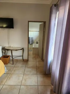 a living room with a table and a mirror at View on 83 in Tzaneen